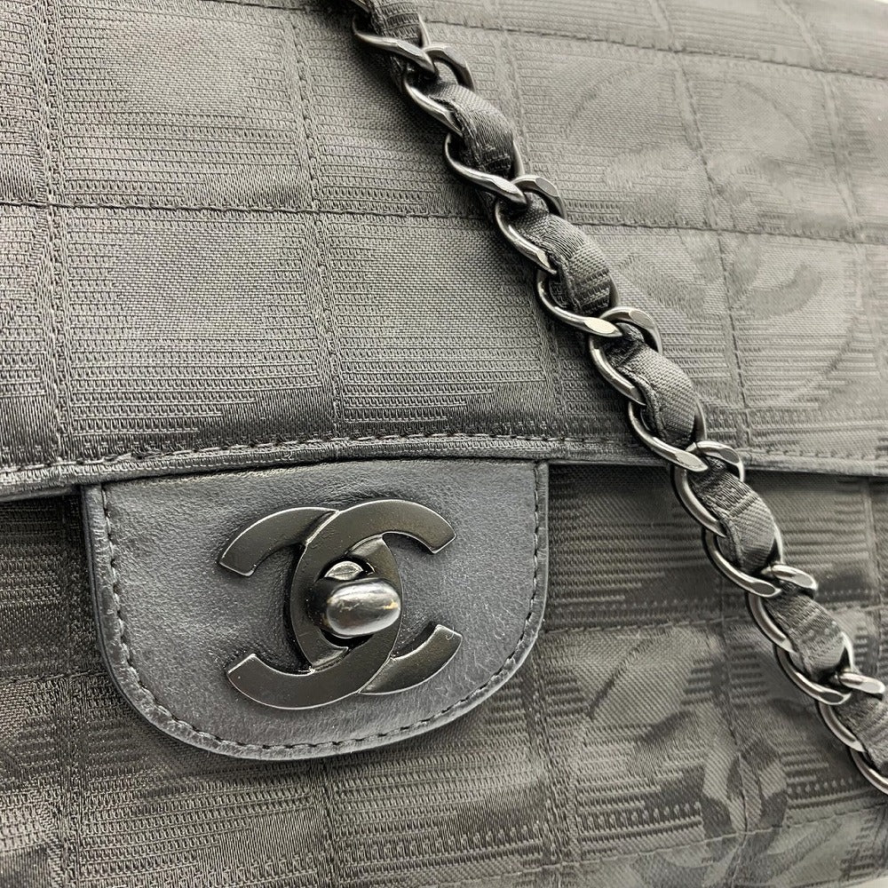 Close-up of a Chanel handbag with a quilted texture and chain detail.